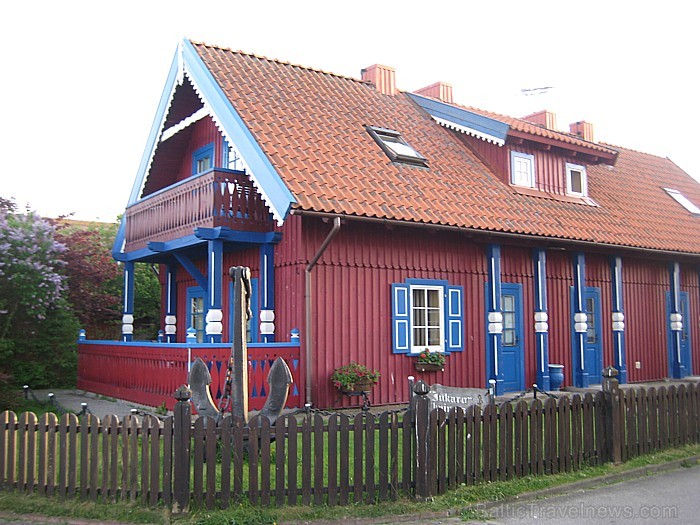 Īpašo šarmu šai vietai piedod arī sarkanbrūnās koka ēkas ar zilajām dekoratīvajām apdarēm un sarkanajiem dakstiņa jumtiem 64954